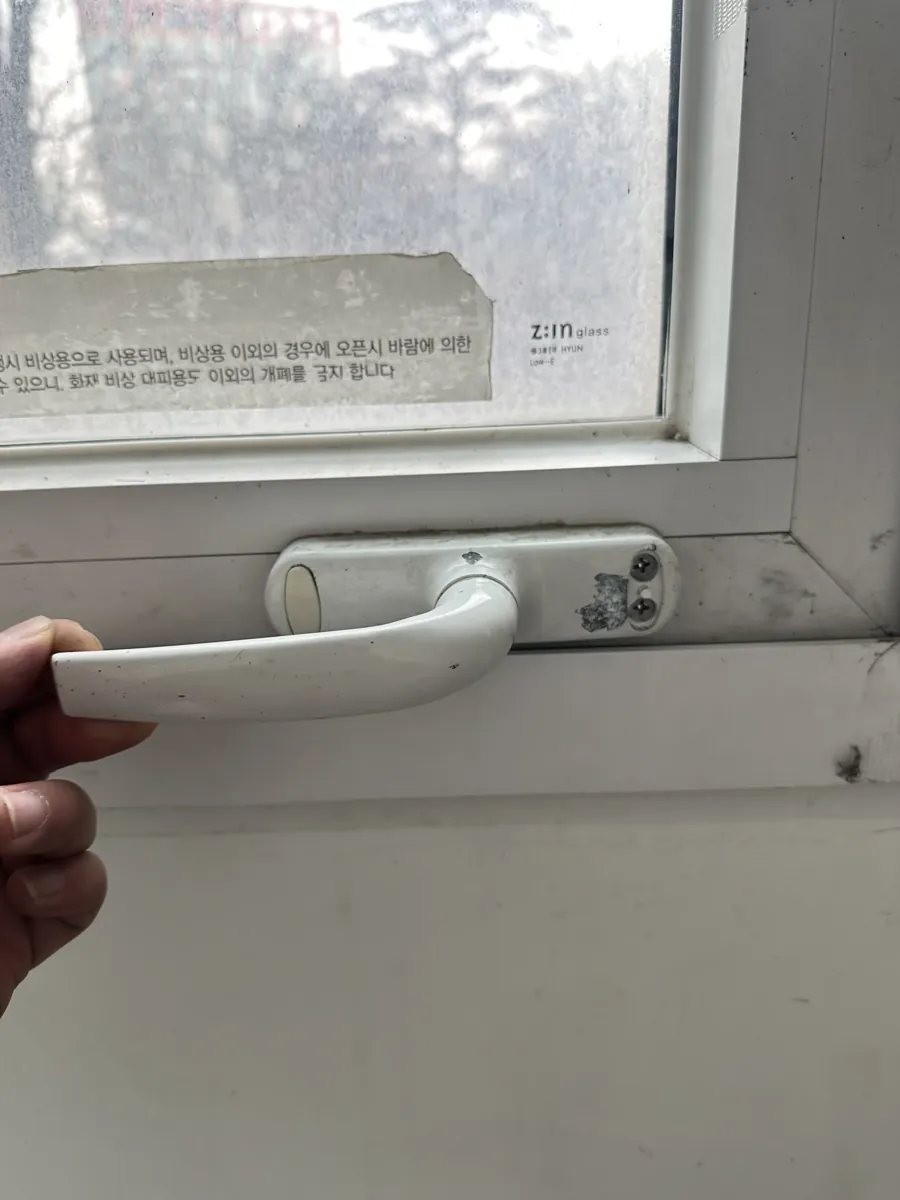 부러져 헐거워진 흰색 창문 손잡이